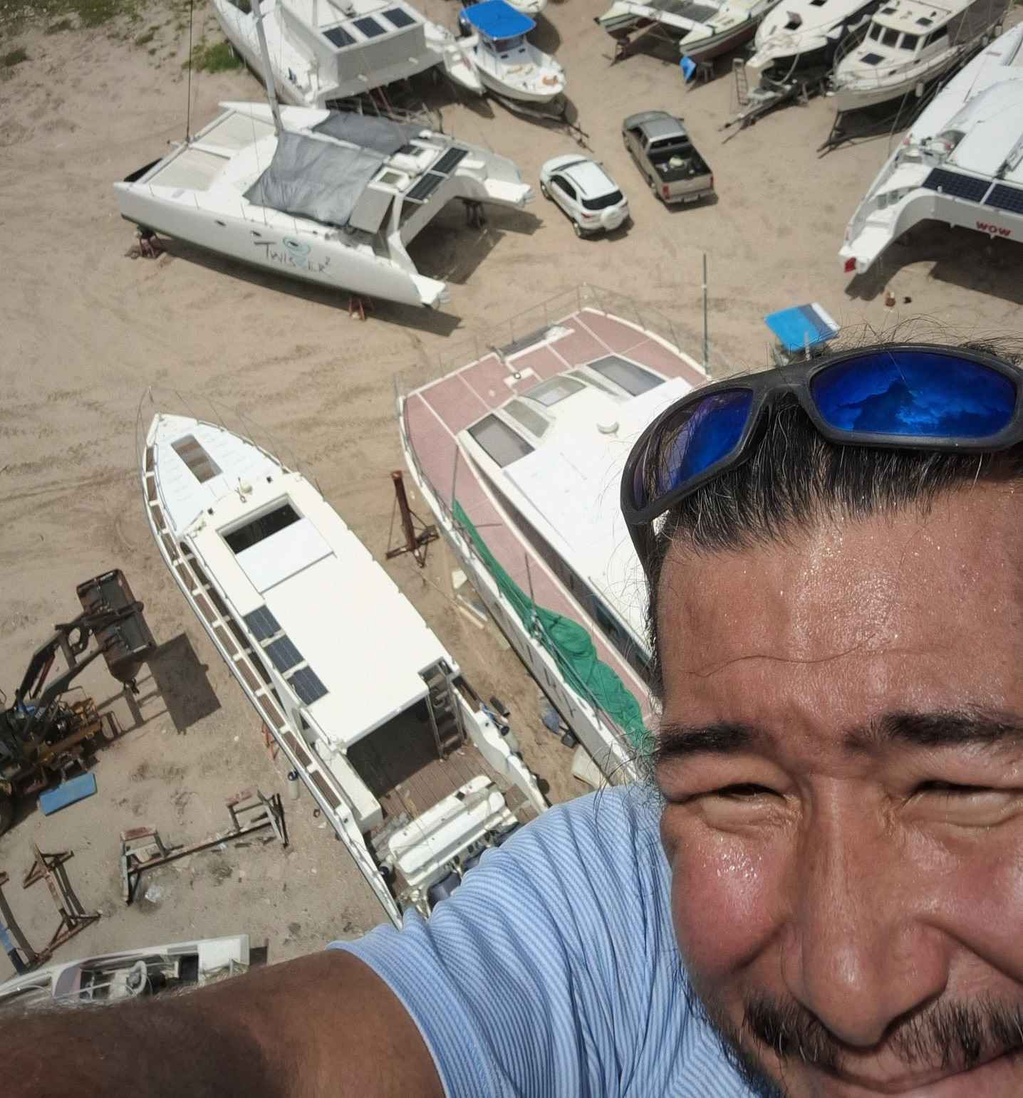 Jason up a mast of a yacht on a hardstand in Phuket